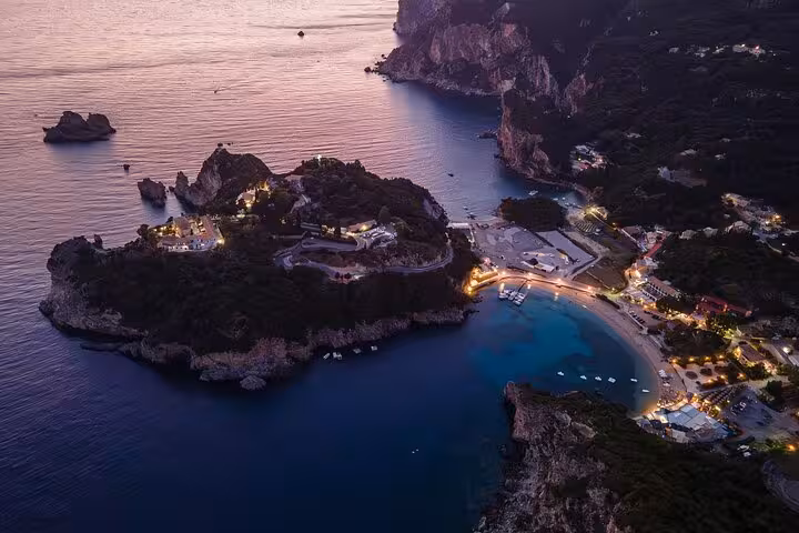 Aerial sunset over Paleokastritsa bay and beach lights in Corfu, private tour with local tastings