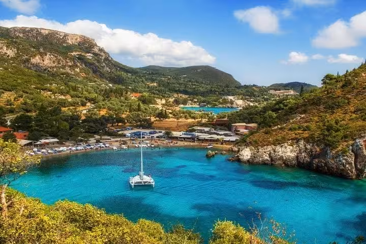Catamaran in crystal-clear Paleokastritsa lagoon, Corfu, scenic stop on private tour with local food tastings