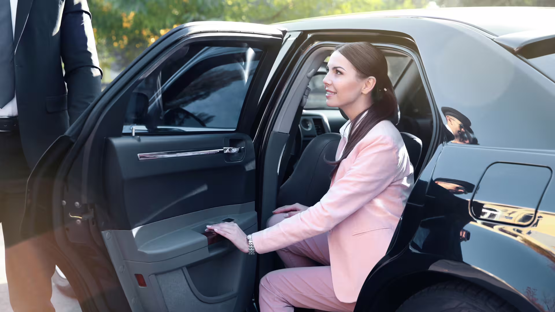 Business traveler in pink suit stepping from a luxury sedan during private transfer from Palermo airport to Taormina, Sicily