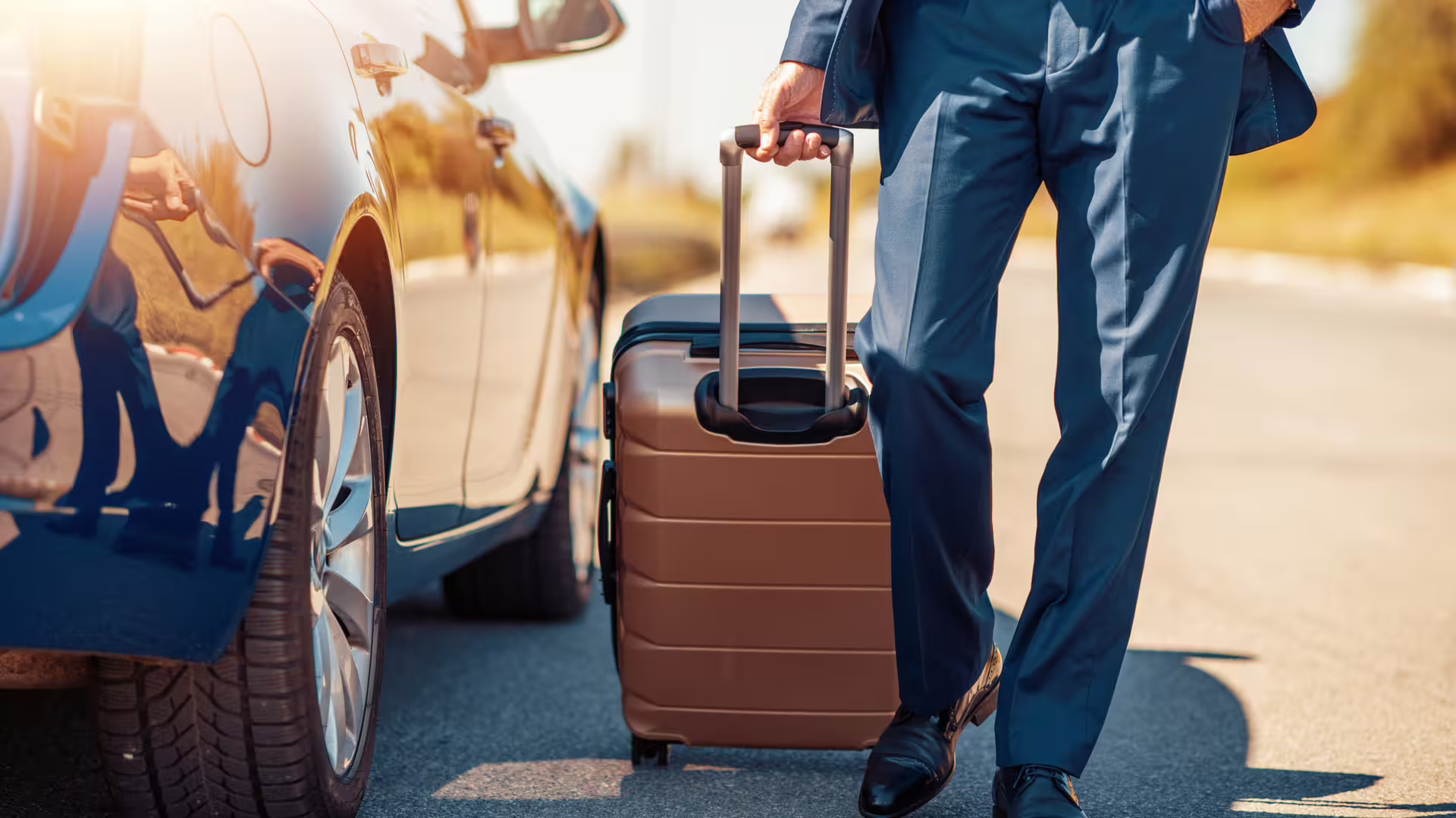 Business traveler with suitcase beside private car, ready for Palermo Airport to Trapani Port transfer service