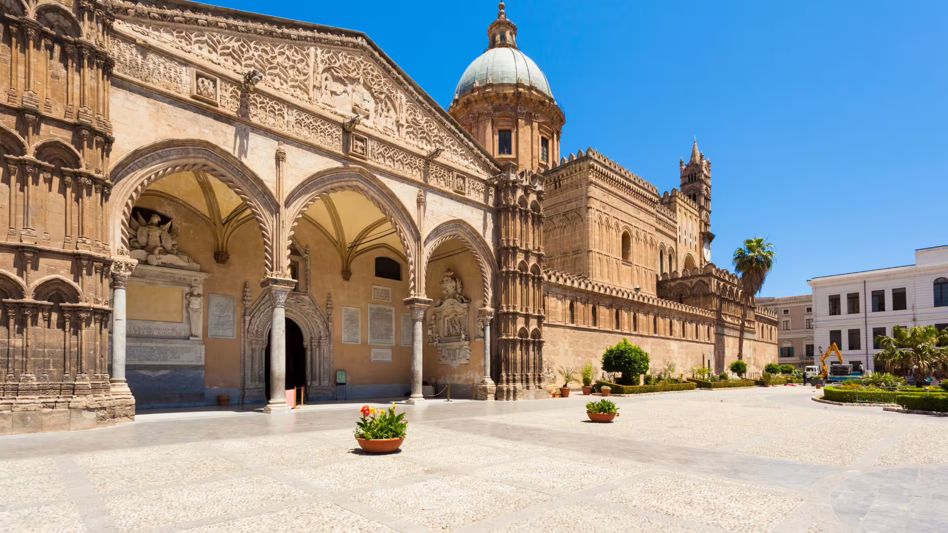Sunlit façade of Palermo Cathedral with ornate arches and dome, a highlight of private Monreale and Mondello day tour