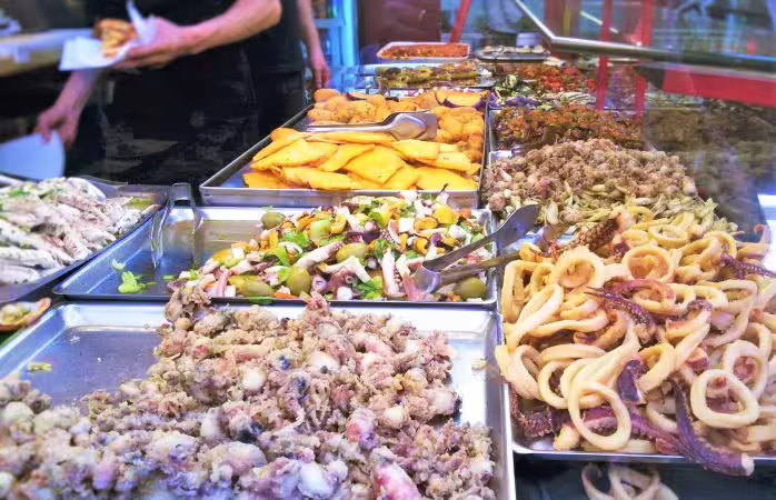 Colorful trays of fried seafood and Sicilian street food in a Palermo market on a Monreale and Mondello day tour