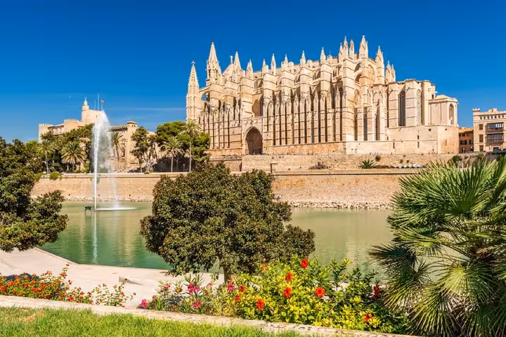 Gothic Palma de Mallorca Cathedral with fountain and gardens under blue sky