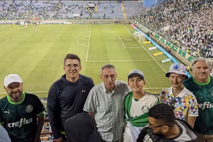 Group of Palmeiras supporters posing by the pitch inside Allianz Parque on São Paulo Palmeiras game experience tour