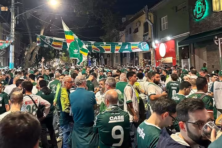 Palmeiras supporters gathering on São Paulo street with green flags before match, local fan experience tour