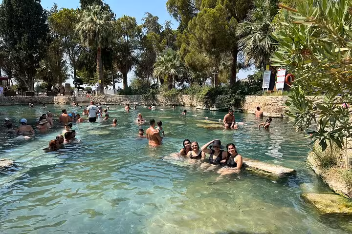 Tourists relaxing in Cleopatra Antique Pool at Pamukkale on full-day tour from Selcuk and Kusadasi