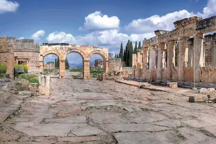 Walk through the ancient ruins of Hierapolis in Pamukkale on a private tour from Kusadasi Port, featuring iconic arches.