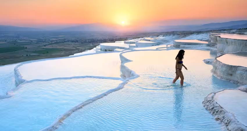 Traveler wading in Pamukkale thermal pools at sunset on 8-day Turkey tour from Istanbul to Cappadocia