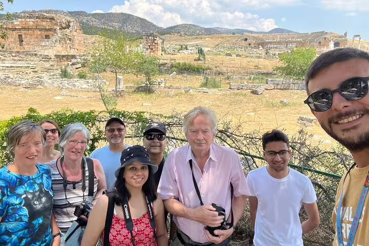 Tourists enjoying a guided exploration of ancient ruins on the private Pamukkale tour from Kusadasi Port.