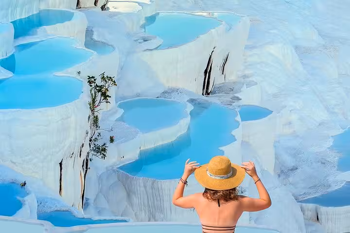 Traveler overlooking Pamukkale white travertine terraces and blue pools on 2-day Ephesus tour from Istanbul
