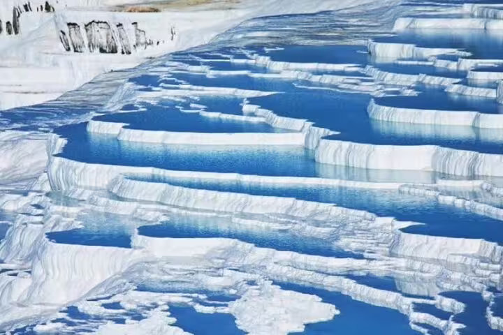 Stunning travertine terraces of Pamukkale, filled with turquoise thermal waters, featured in the Istanbul tour package.