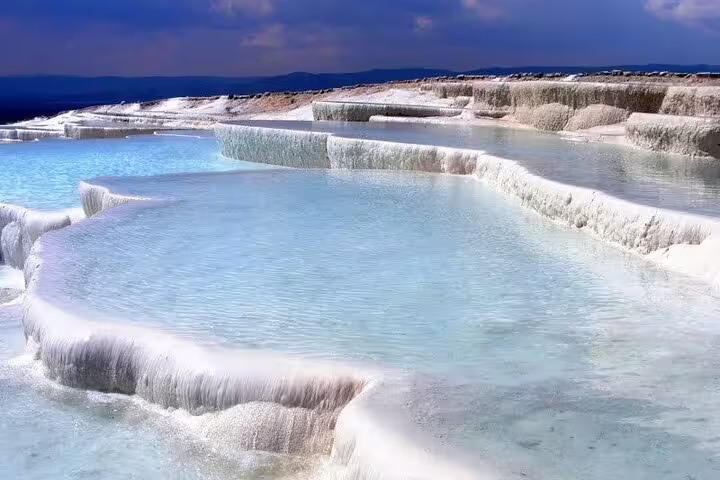 Stunning view of Pamukkale's natural travertine terraces with azure thermal pools on a small group tour from Izmir.