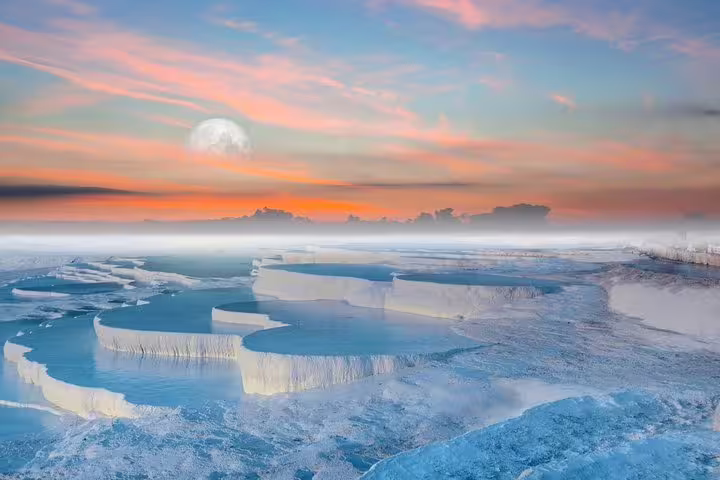 Stunning sunset over the white travertine terraces of Pamukkale, a must-see on the private tour from Kusadasi Port.