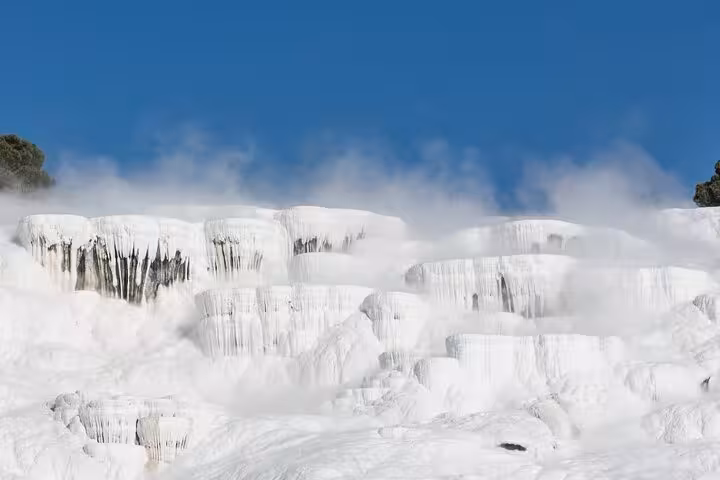 Pamukkale white travertine terraces steaming under blue sky on an all-inclusive private guided tour in Turkey
