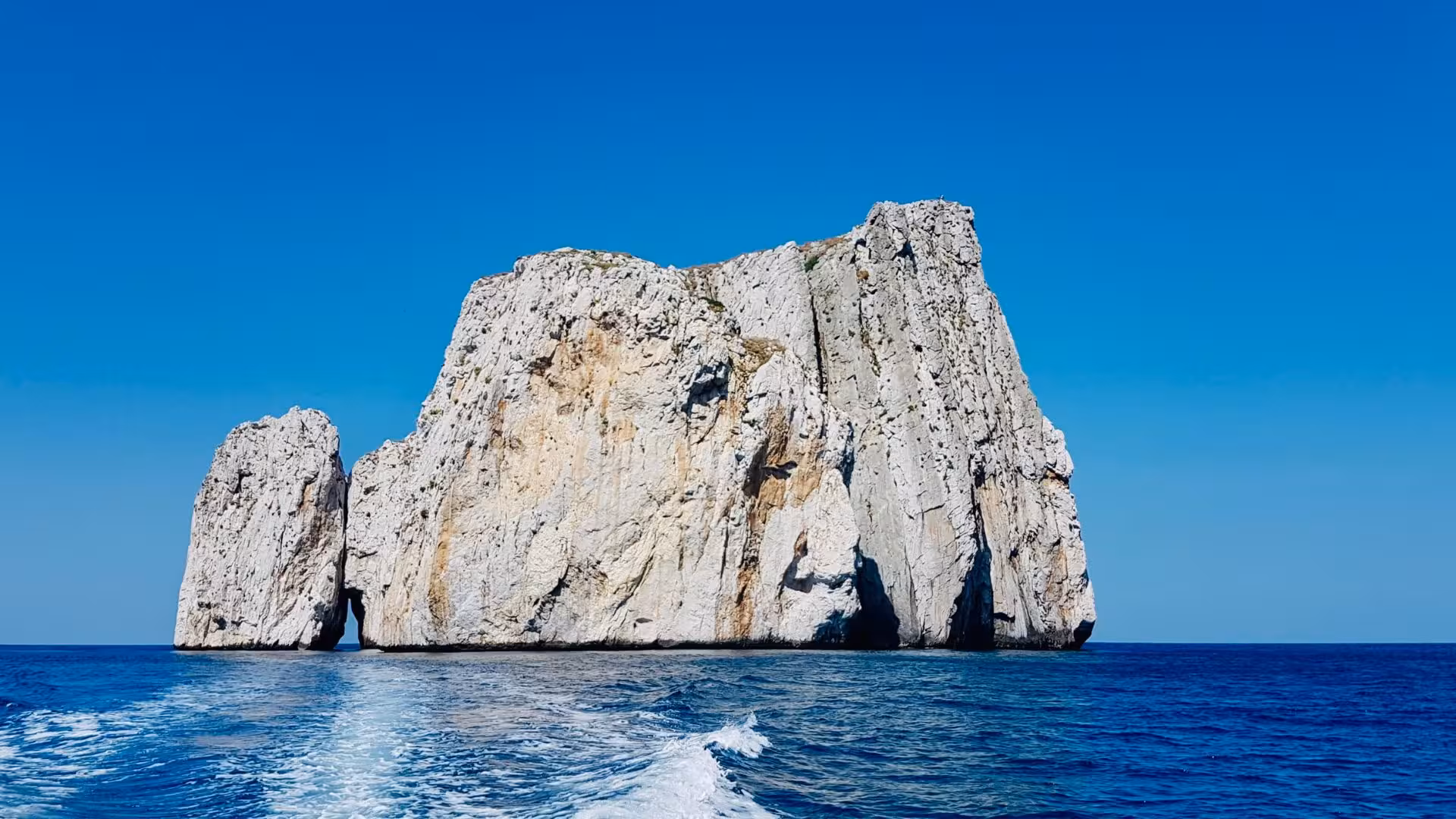 Scenic view of Pan di Zucchero rock formation rising from the clear blue waters near Buggerru, Sardinia.