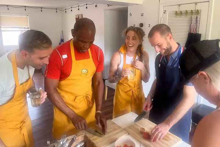 Group of people enjoying a fun and interactive Panamanian cooking class, wearing aprons and preparing ingredients.