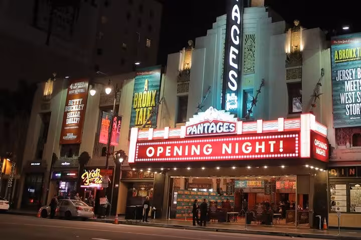 Pantages Theatre Hollywood lit up at night with Opening Night marquee and Broadway show banners