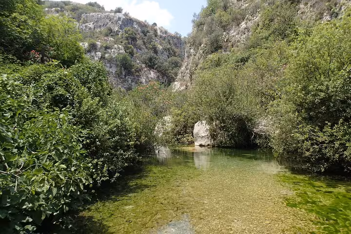 Discover the serene crystal-clear waters and verdant cliffs of Pantalica's enchanting landscapes on a full day Sicily tour.