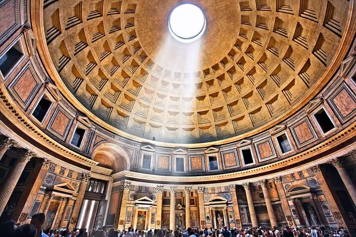 Interior of the Pantheon with sunlight streaming through the oculus, illuminating the ornate dome and visitors.