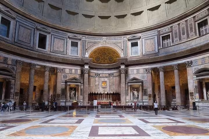 Spacious view of the Pantheon's majestic interior, highlighting the intricate dome and detailed architectural design.