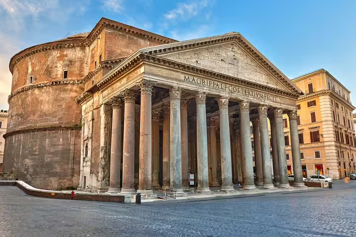 The Pantheon in Rome with ancient columns and Roman inscription under blue sky