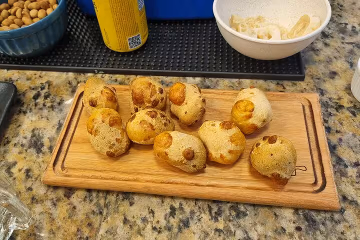 Traditional Brazilian cheese bread, pão de queijo, served on a wooden board, perfect for a culinary experience in Rio.