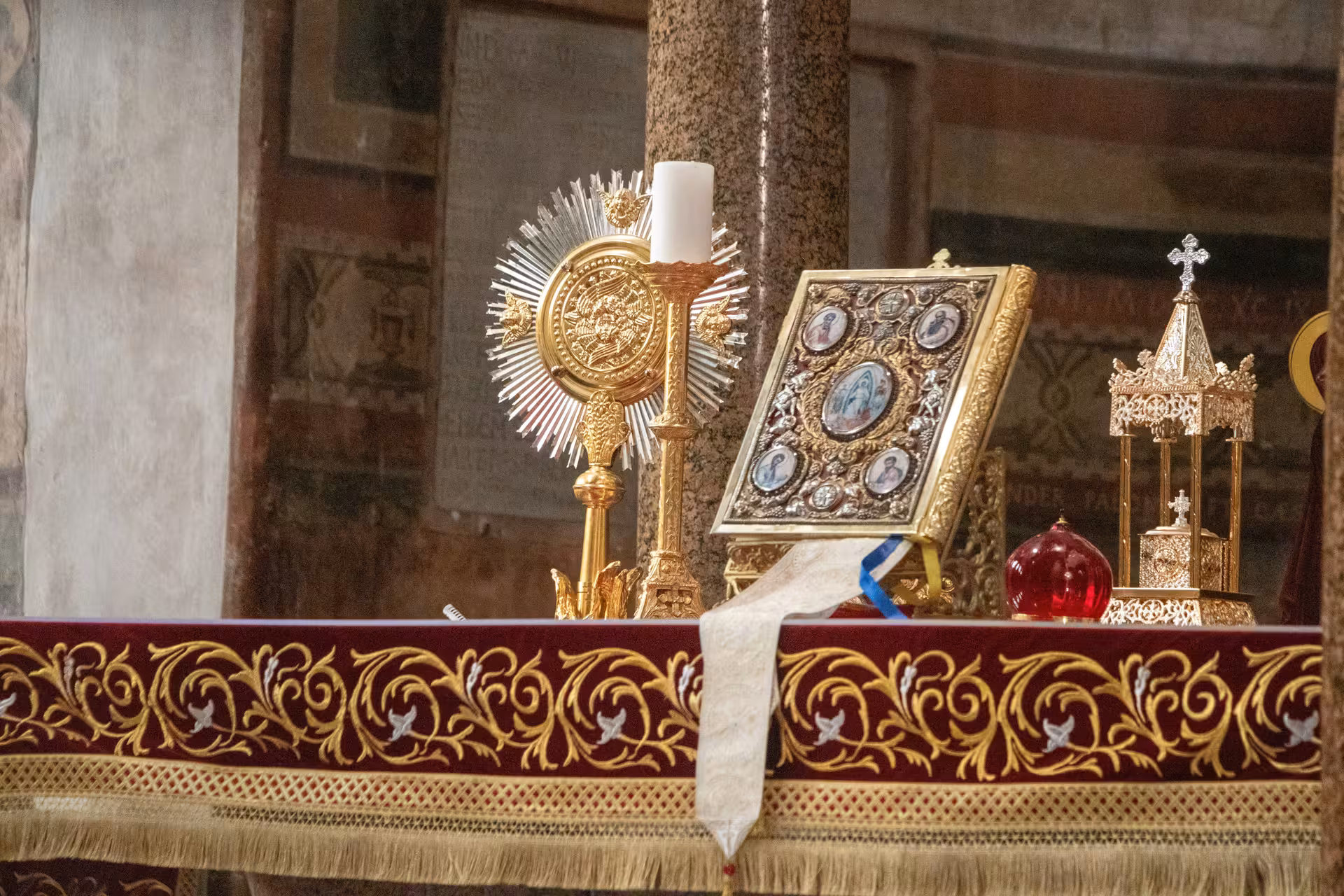 Ornate altar with religious artifacts inside a Papal Basilica, showcasing intricate gold and silver designs.