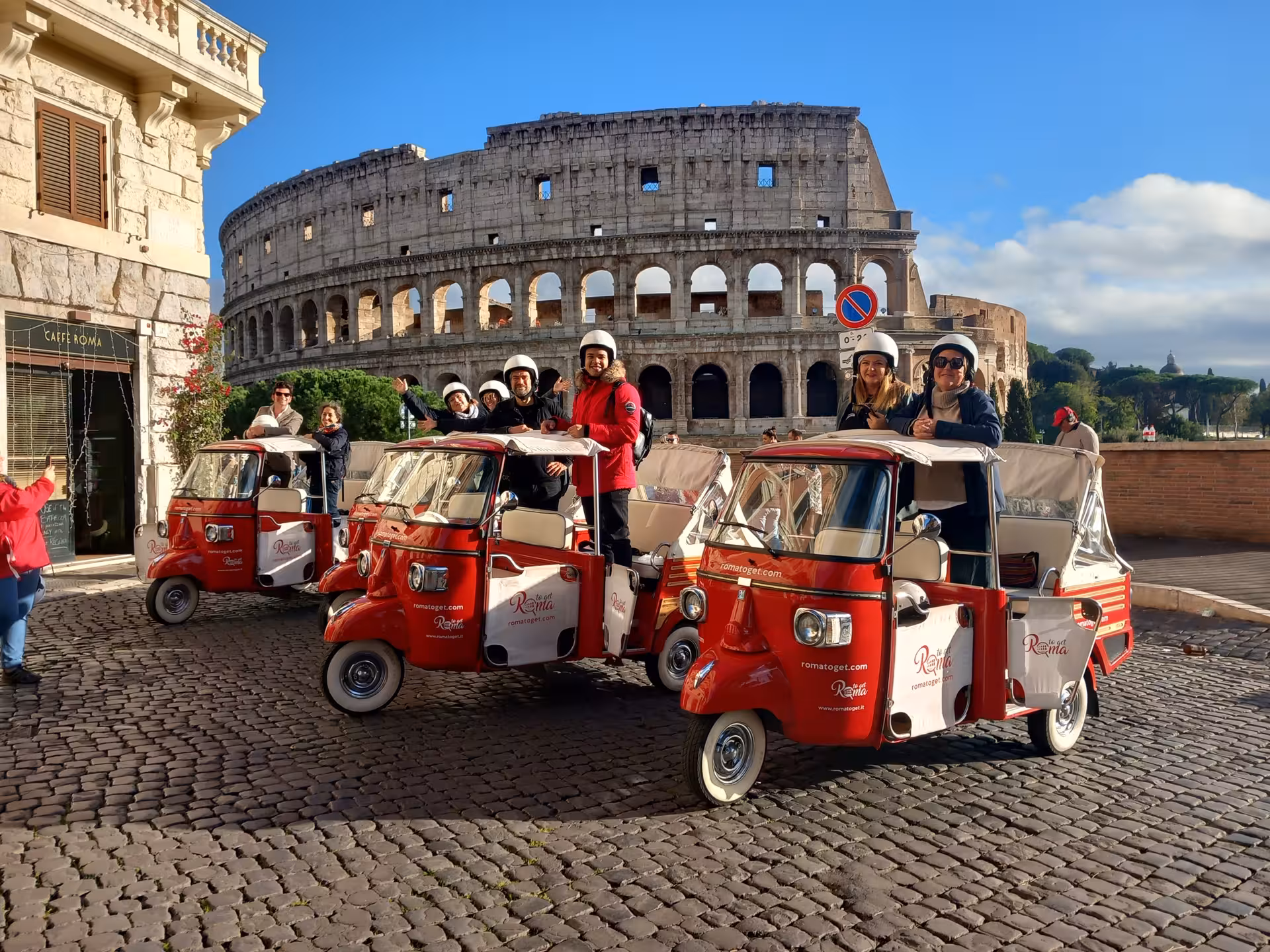 Tourists on tuk-tuks enjoy a sunny ride with the iconic Colosseum backdrop on the Papal Basilicas tour.