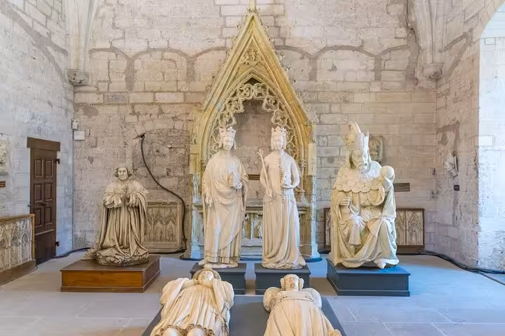 Medieval stone sculptures and Gothic arch inside the Papal Palace in Avignon, France