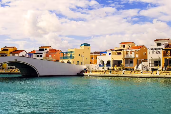 Paphos Marina waterfront with colorful houses and arched bridge on Southern Cyprus sightseeing tour from Larnaca