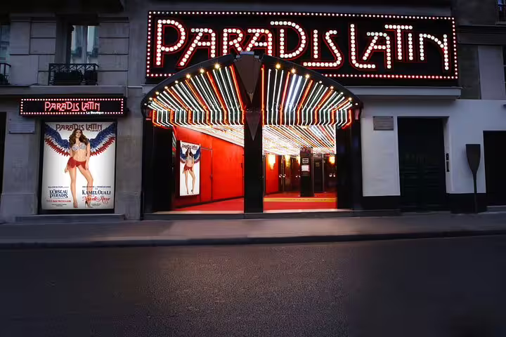 Paradis Latin cabaret venue entrance with illuminated neon sign and colorful marquee lights in Paris
