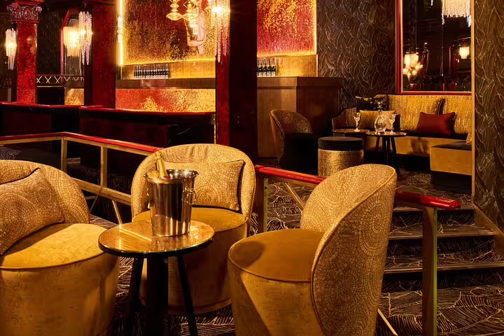 Luxurious gold velvet lounge seating with champagne bucket at Paradis Latin cabaret Paris