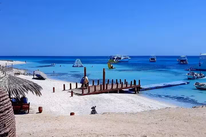 Paradise Island Hurghada VIP snorkeling day trip with wooden jetty, calm Red Sea lagoon and boats offshore