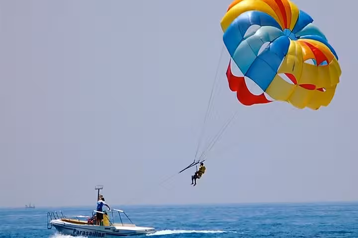Colorful parasail flying behind boat on Red Sea, Hurghada El Gouna Soma Bay parasailing trip with pickup
