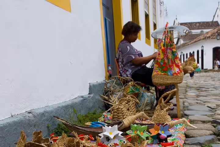 Artisan crafts on display in Paraty, Brazil, showcasing traditional handwoven items during a historical walking tour.