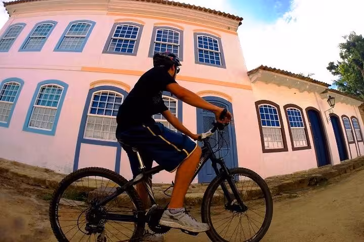 Cyclist enjoying a scenic ride past colorful colonial architecture in Paraty on a guided 2-hour bike tour.