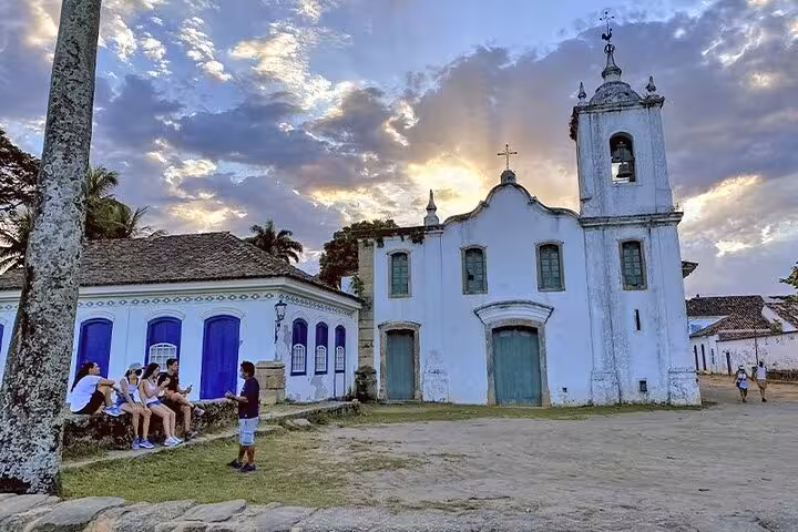 Discover Paraty's historic charm with a sunset view of a church and colonial buildings during the walking tour.