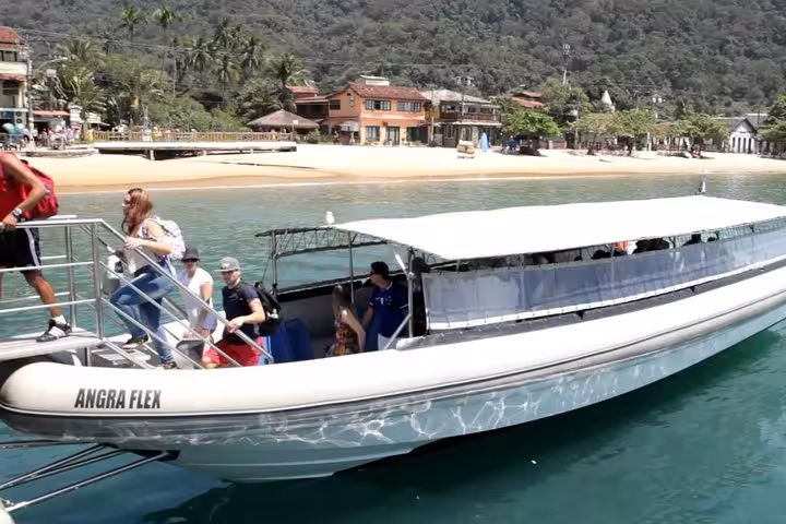 Tourists boarding a speedboat at the vibrant coast of Ilha Grande for a scenic transfer experience.