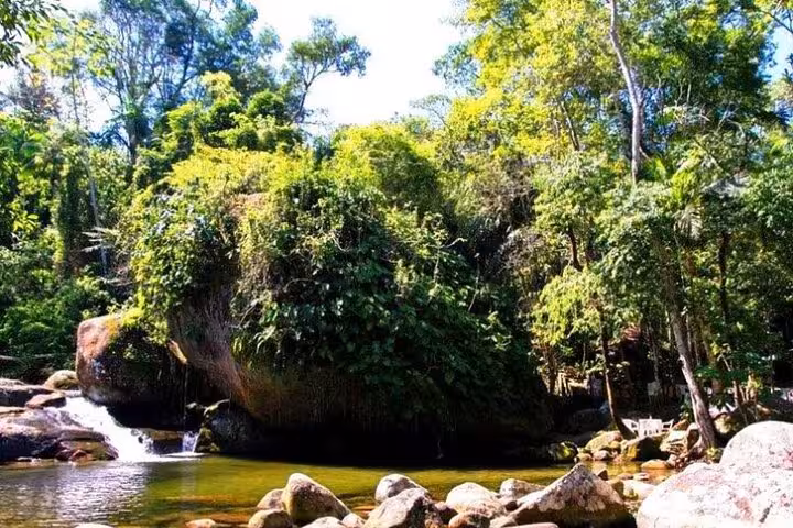 Scenic view of a tranquil river surrounded by dense greenery in Paraty, perfect for a serene jeep tour stop.