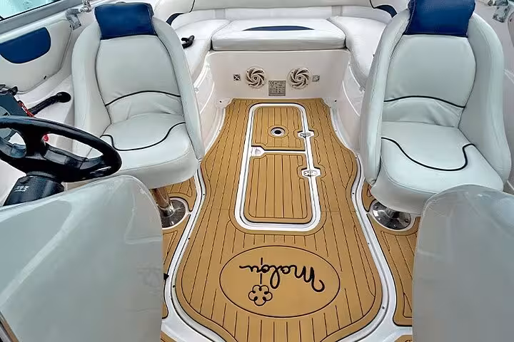 Luxurious boat interior with plush white seating and elegant wooden flooring for Paraty exclusive boat tour.