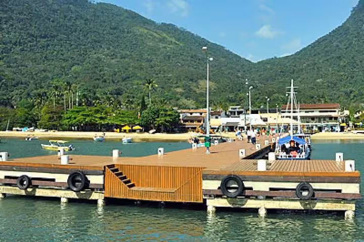 Scenic view of Paraty pier with lush green mountains, a key departure point for Ilha Grande transfers.