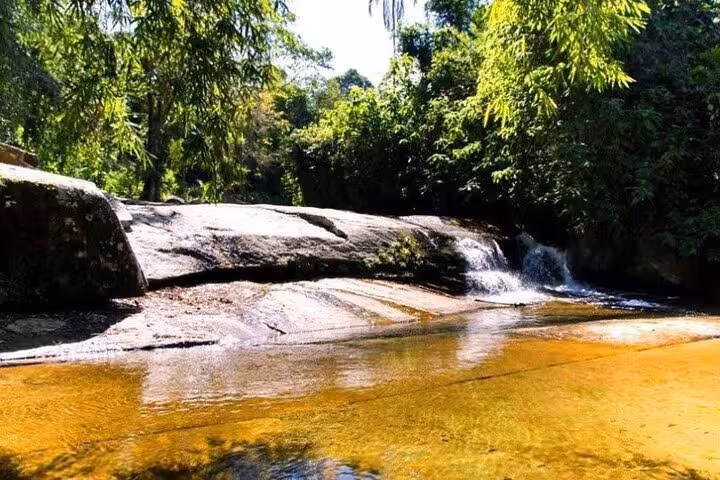 Pristine waterfall cascading over rocks in a tropical Paraty forest, a highlight of private jeep tours.