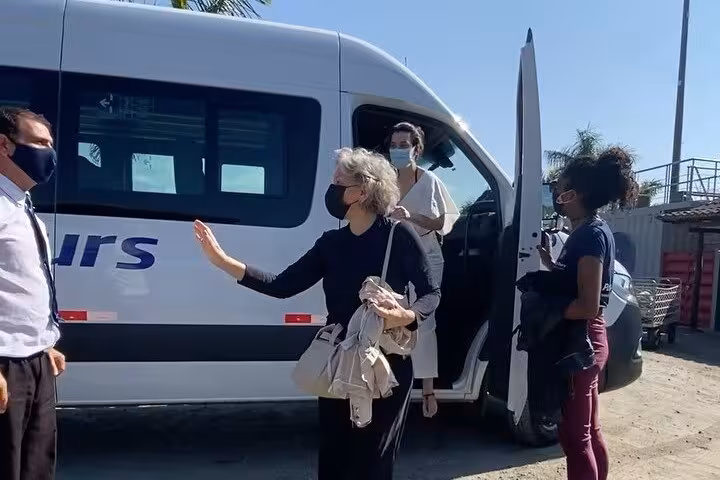Travelers with masks boarding a shared transfer van from Paraty to Rio de Janeiro, highlighting safe group travel.