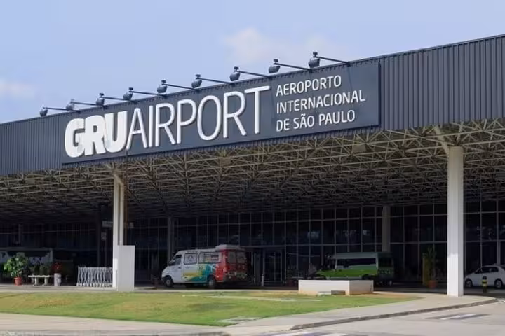 Entrance of São Paulo's GRU Airport, showcasing signage and shuttle vans for travelers arriving from Paraty.