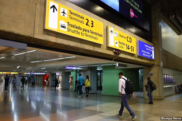 Terminal signs at GRU Airport directing travelers to shuttle services, ideal for Paraty to São Paulo transfers.