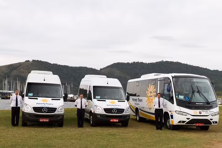 Fleet of Paraty Tours shuttle vans and bus with drivers ready for shared transfer service to São Paulo.