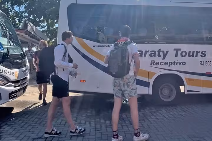 Tourists prepare to board a Paraty Tours bus, showcasing shared transfers from Paraty to hotels in Rio de Janeiro.