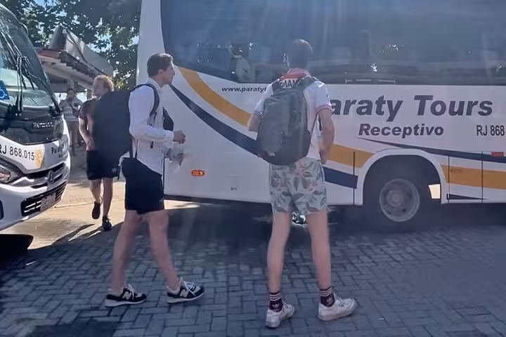 Travelers boarding a Paraty Tours bus, ready for a shared transfer to the stunning Ilha Grande.