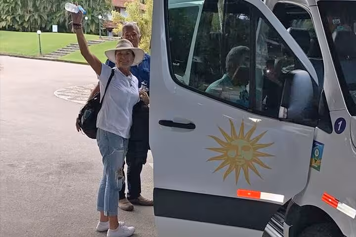 Tourist boarding a Paraty Tours van for a shared transfer to Ilha Grande, highlighting convenient travel services.