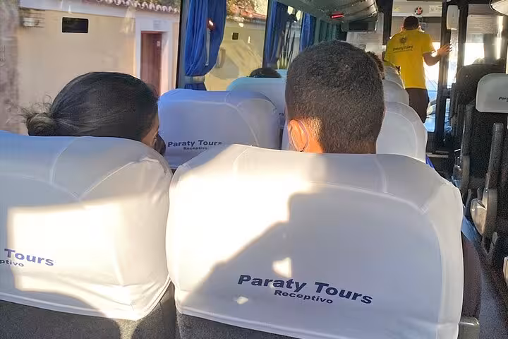 Passengers seated on Paraty Tours bus during shared transfer to Rio de Janeiro, showcasing comfortable travel experience.